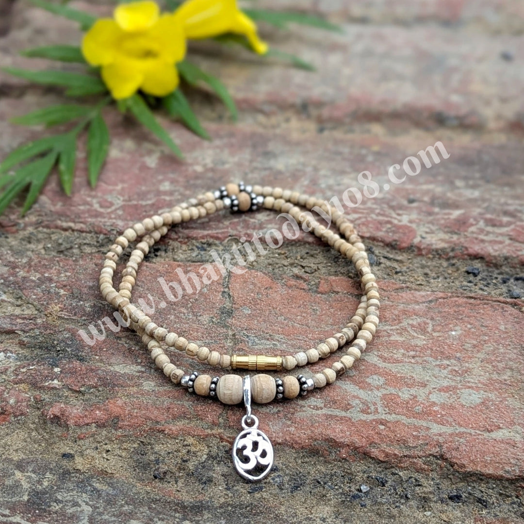 Tulsi silver bracelet with Om design – features sacred Tulsi beads interwoven with a silver Om symbol, representing spirituality and protection.