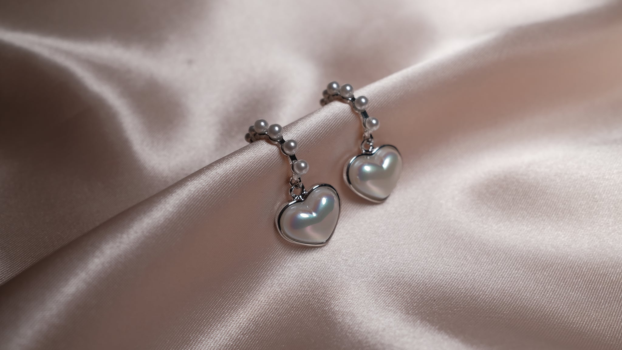 Pearl Heart silver earrings featuring a delicate heart-shaped design with a lustrous pearl center, set in polished silver for an elegant and timeless look.