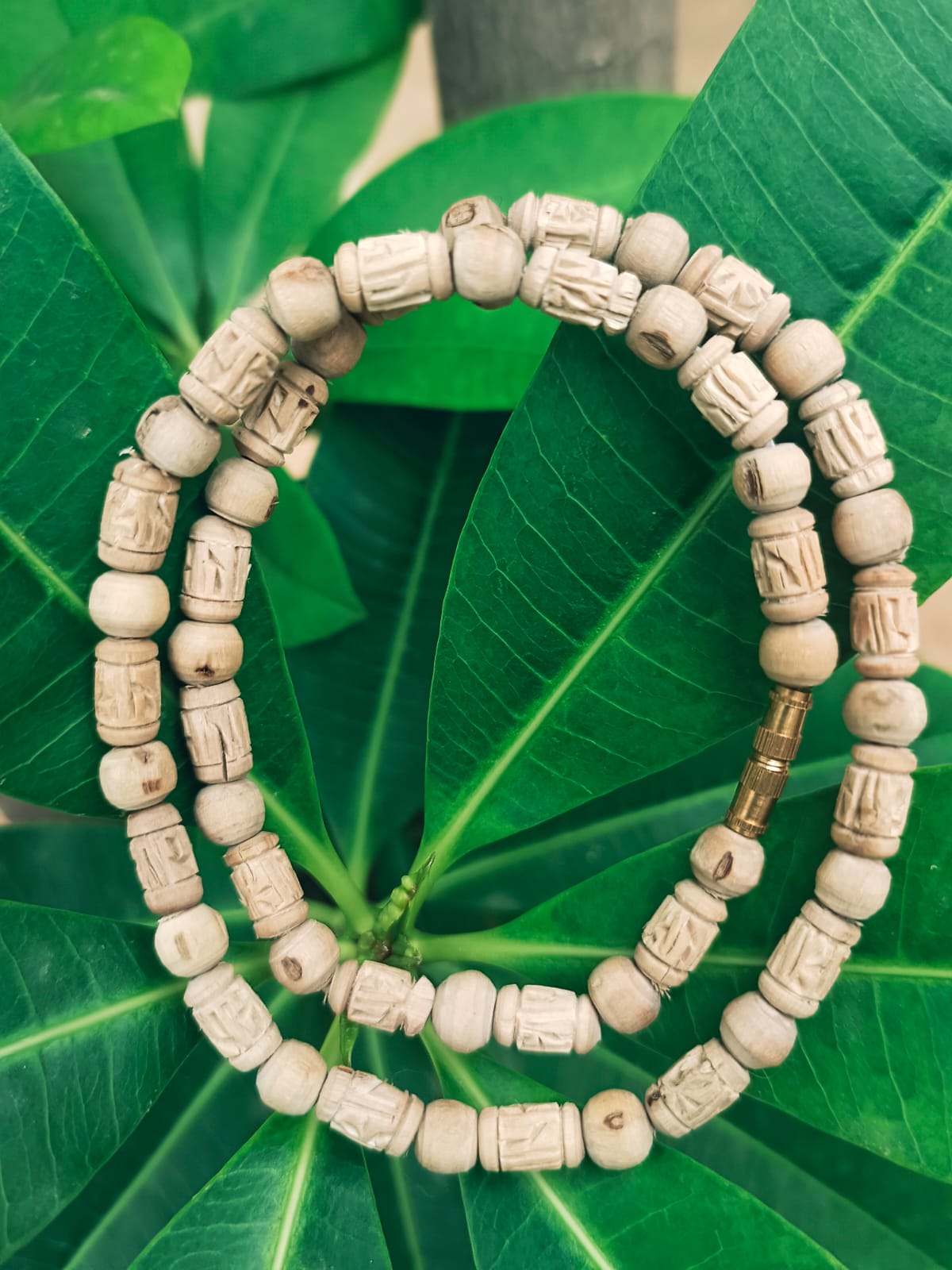 Radha Naam Tulsi Mala made from pure Tulsi wood with Radha's name engraved on each bead, handcrafted in Vrindavan for spiritual protection and devotion.